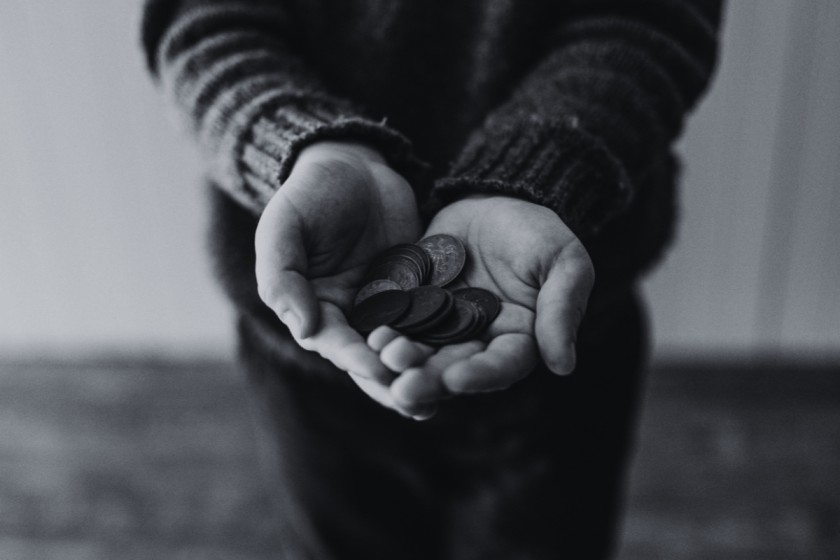 A person's open hands filled with coins as a metaphor of the book editing rates.