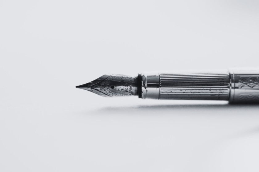 A tip of a fountain pen on a white background as a metaphor for line editing services.
